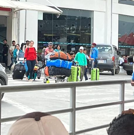 a group of people standing in a parking lot with luggage