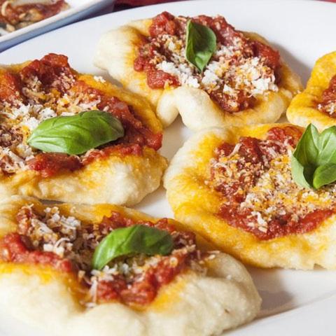 un plat de pizzes petites amb alfàbrega per sobre