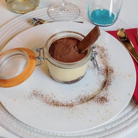 một cái đĩa đựng một cốc bánh pudding sô cô la trên bàn