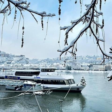 two boats docked on the water with snow on them