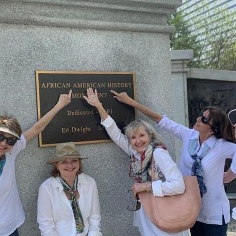 a group of women standing in front of a sign