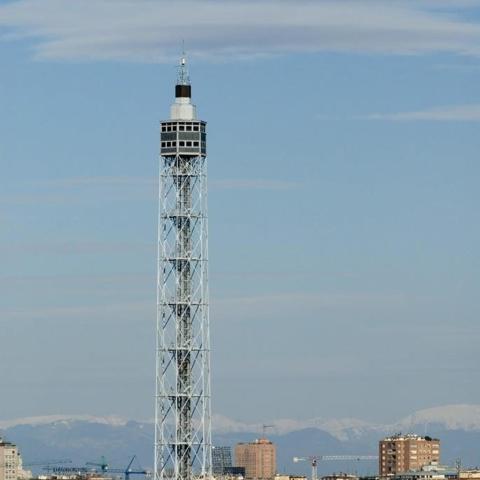 una torre blanca amb una ciutat al fons