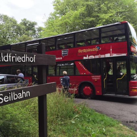ein roter Doppeldeckerbus fährt eine Straße entlang