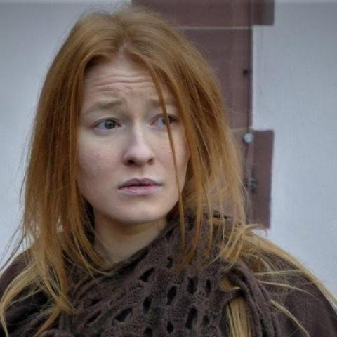 Una mujer pelirroja mirando a la cámara.