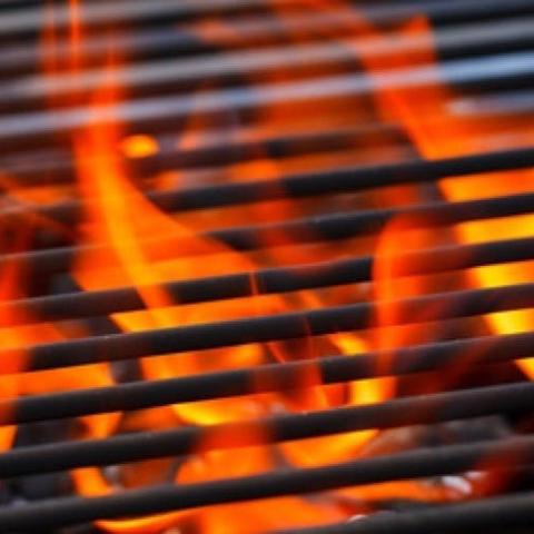 eine Nahaufnahme eines Grills mit orangefarbenen Flammen