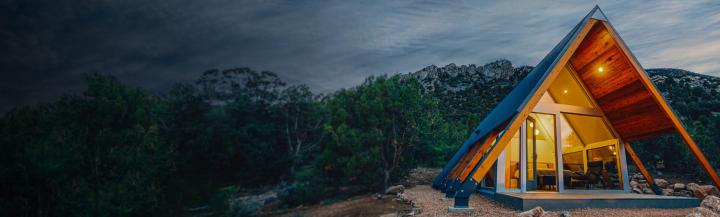 Modern, warmly lit holiday home in the mountains at night