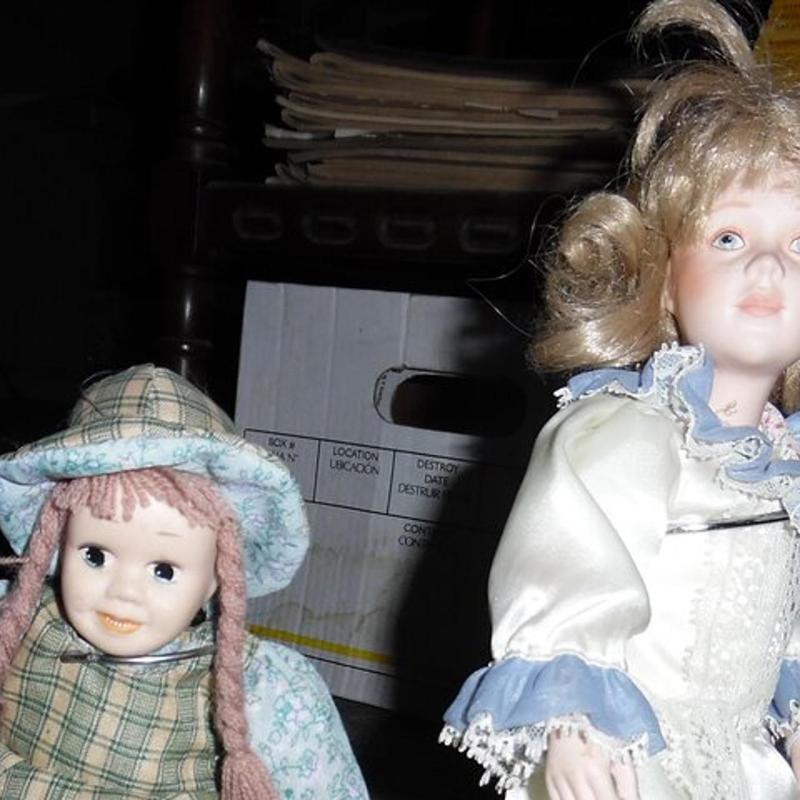two dolls are sitting next to each other