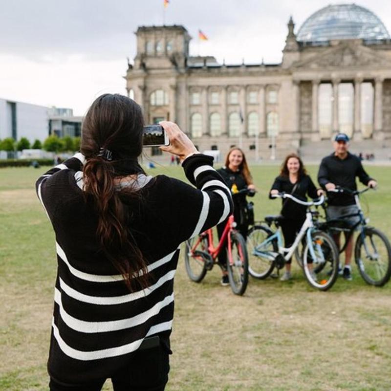 a woman taking a picture of a group of people on bikes
