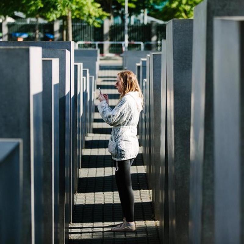 a woman standing on stairs looking at her cell phone