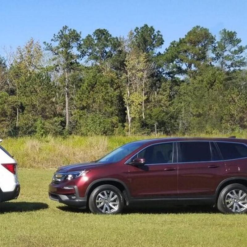 two cars parked next to each other in a field