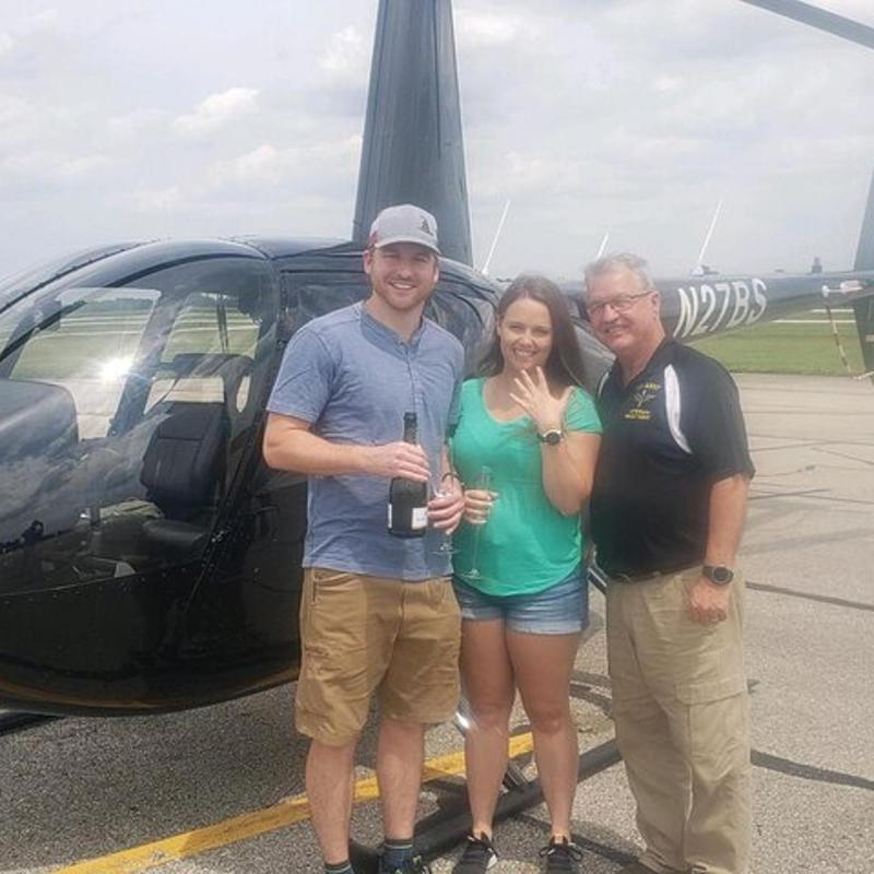 a group of people standing in front of a helicopter