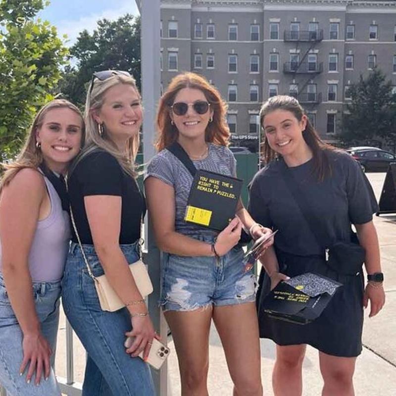 a group of women standing next to a fence