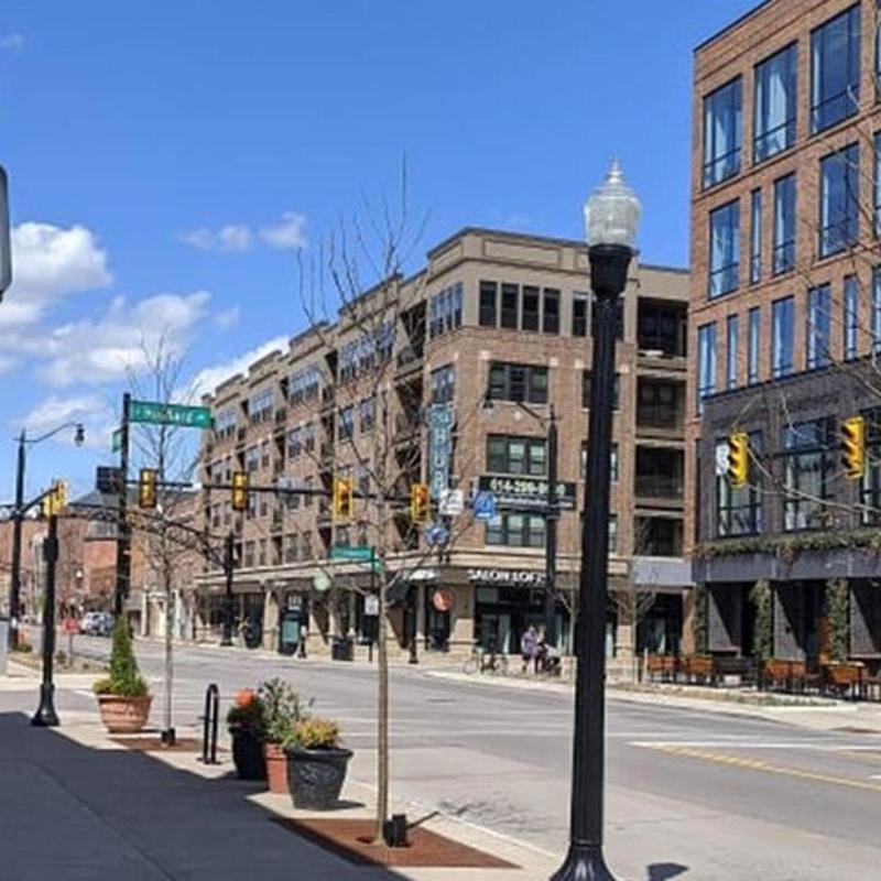 an empty city street with a bar and gamble sign