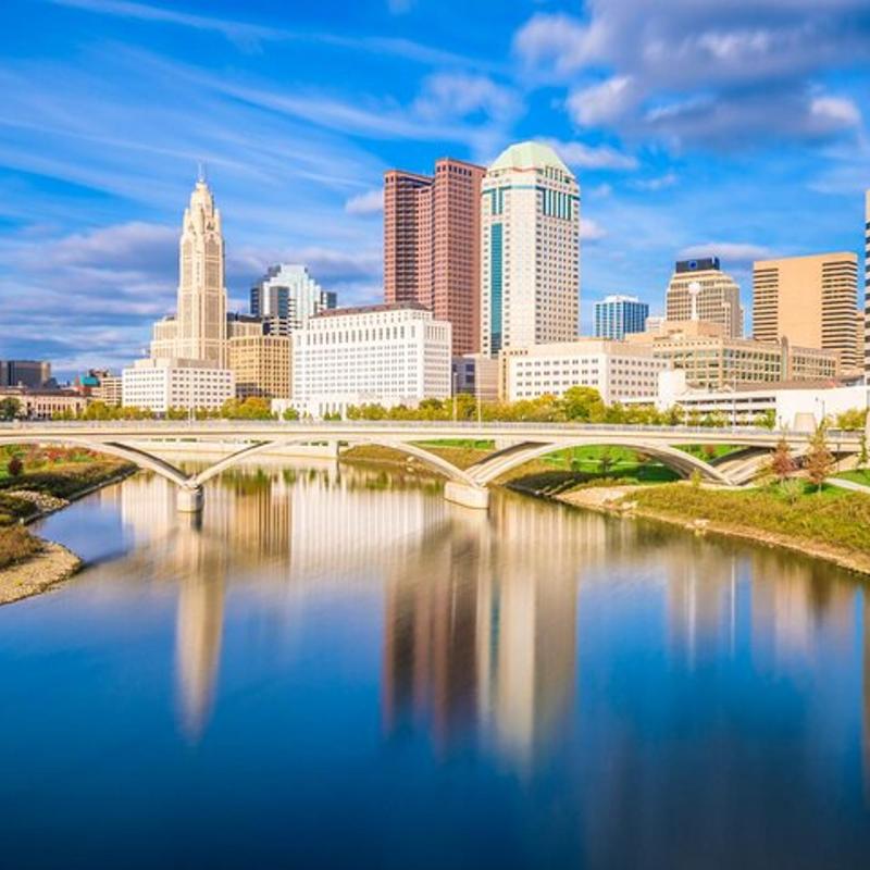 a city skyline with a bridge over a river