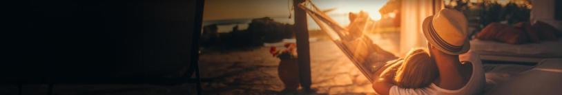 A father and child together in a hammock, watching a beautiful sunrise