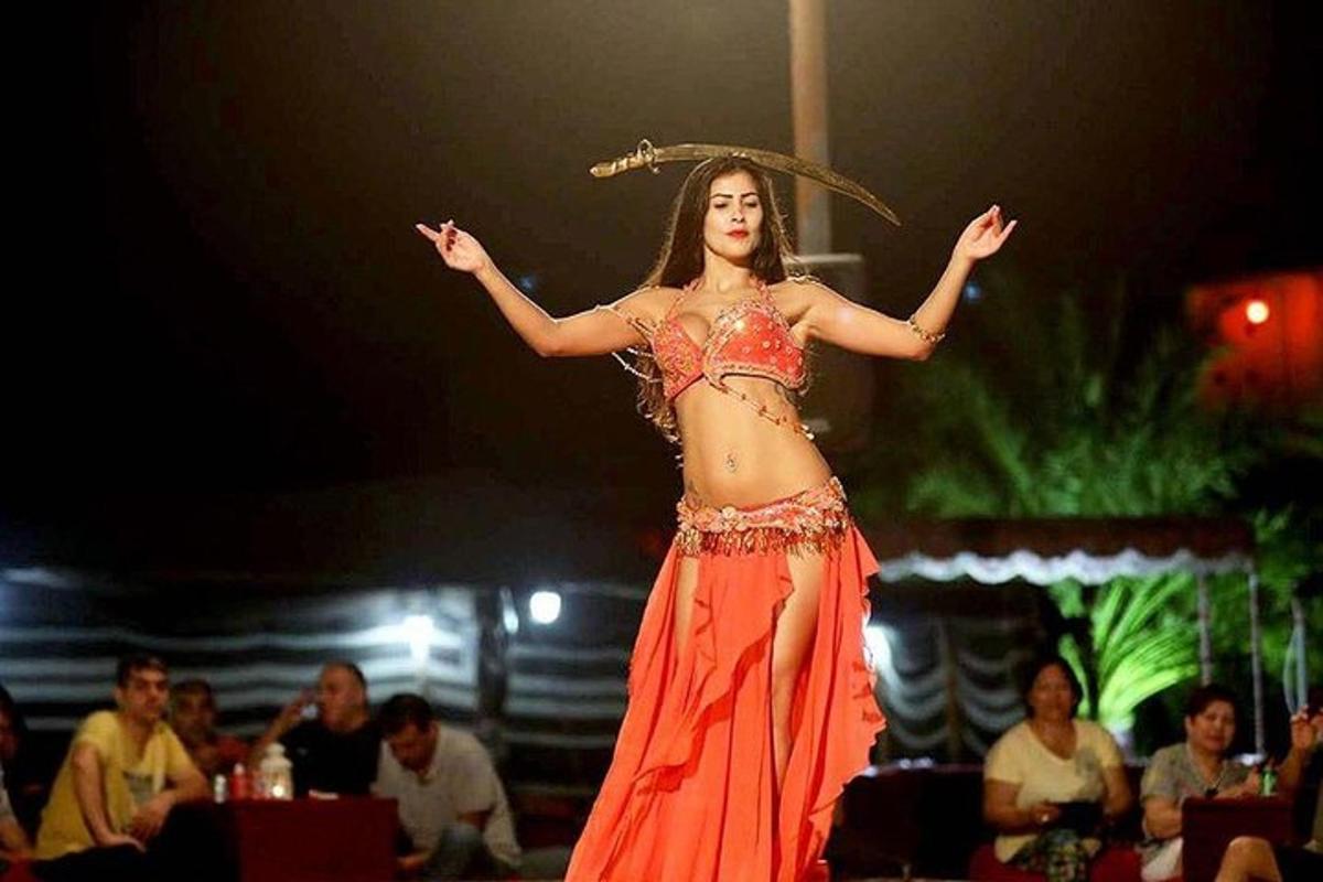 a woman in an orange dress performing on a stage