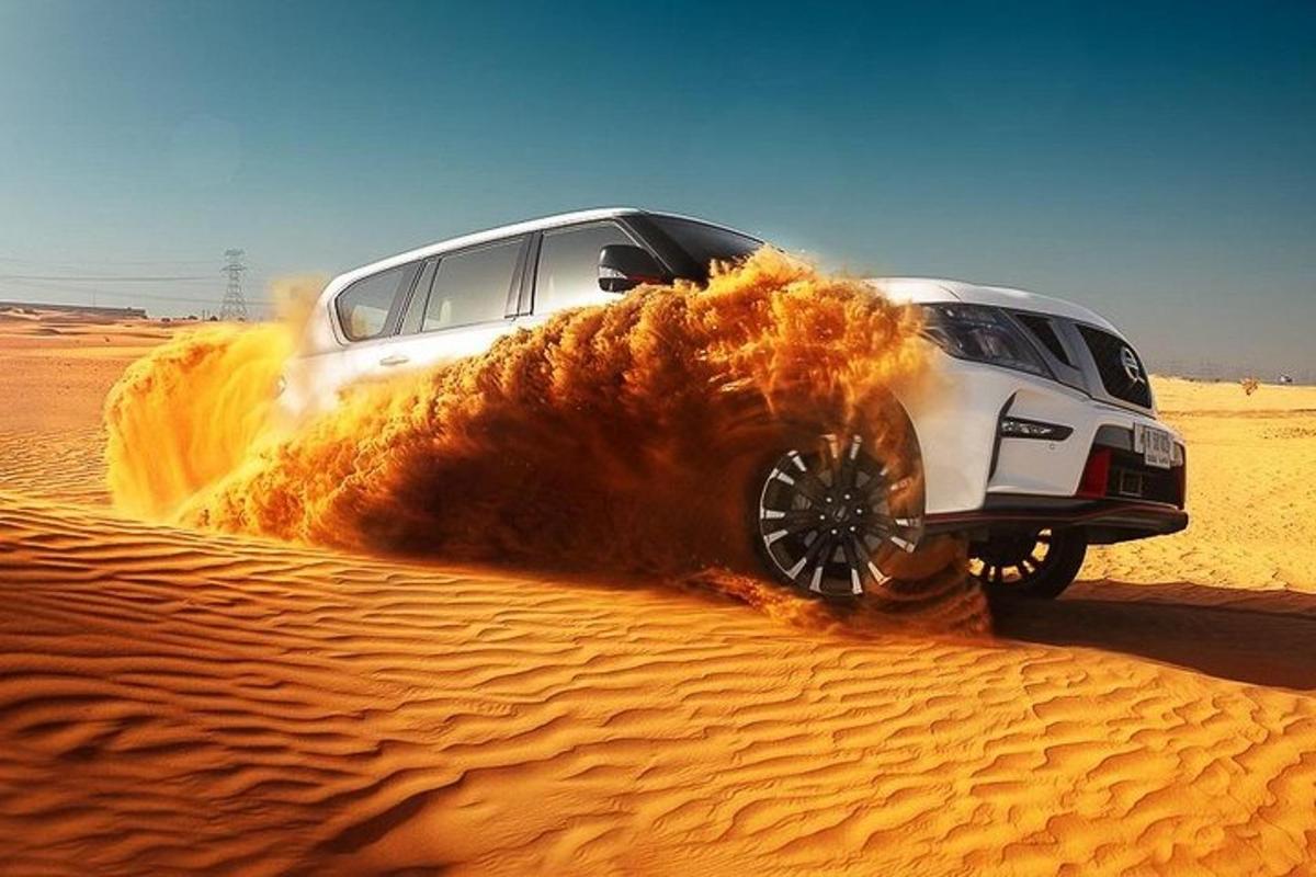 a white car driving through the sand in the desert