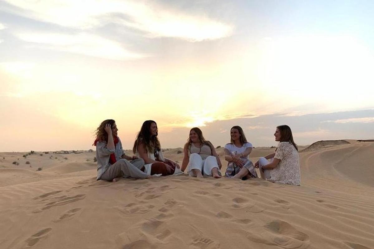 un gruppo di donne sedute sulla sabbia nel deserto