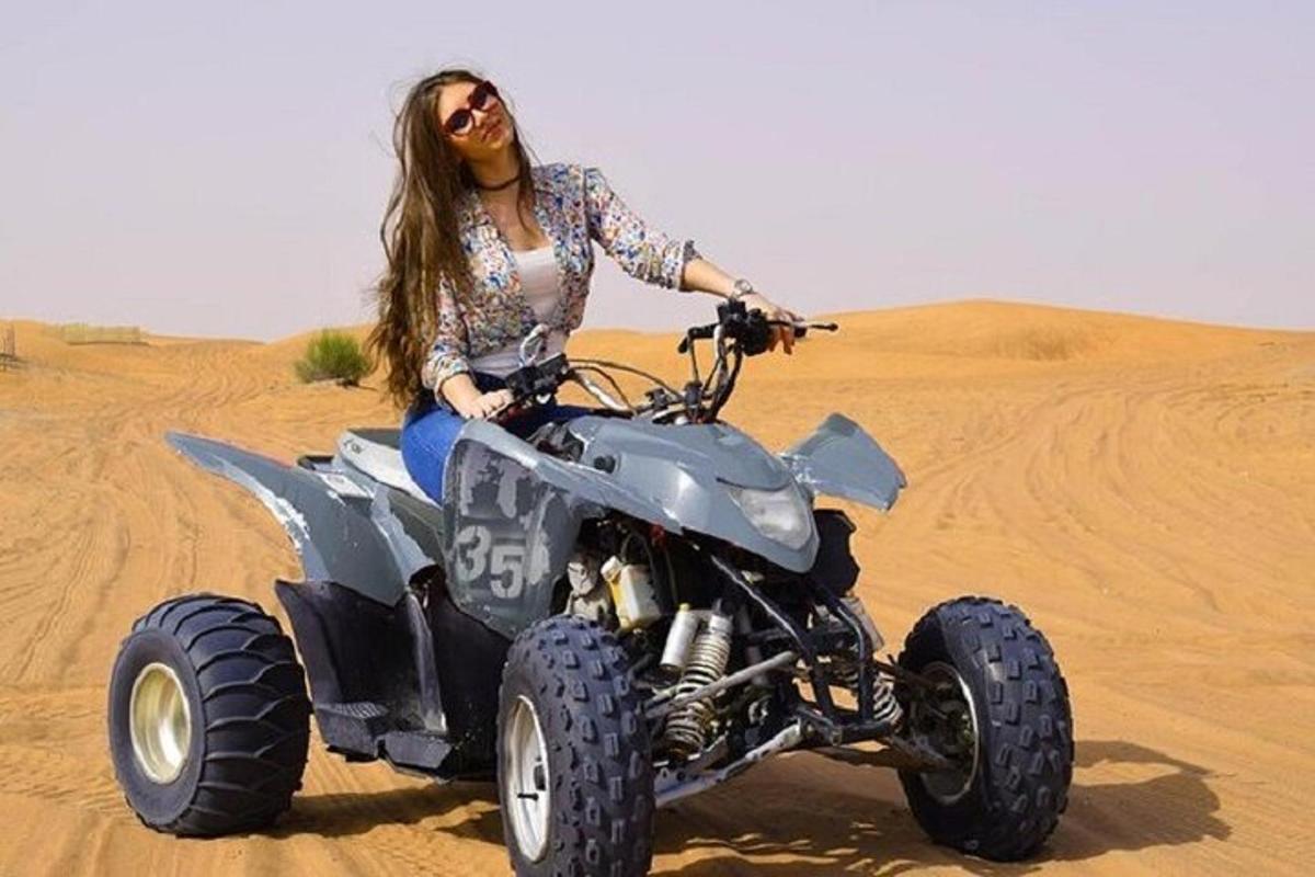 una donna in sella a un quad nel deserto