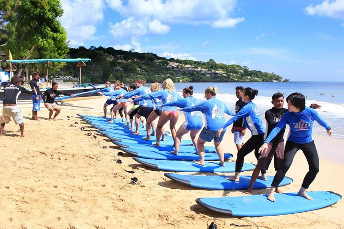 a group of people standing on surfboards on a beach