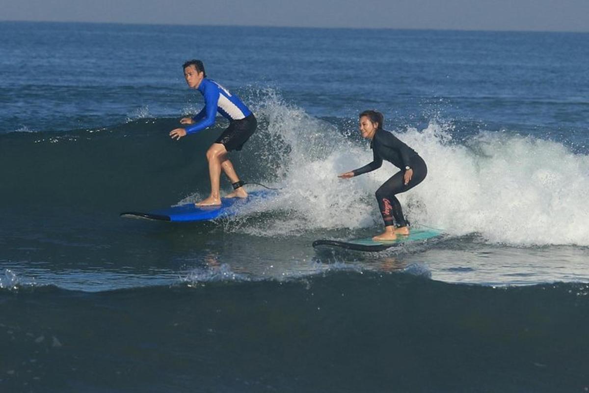 two people riding a wave on surfboards in the ocean