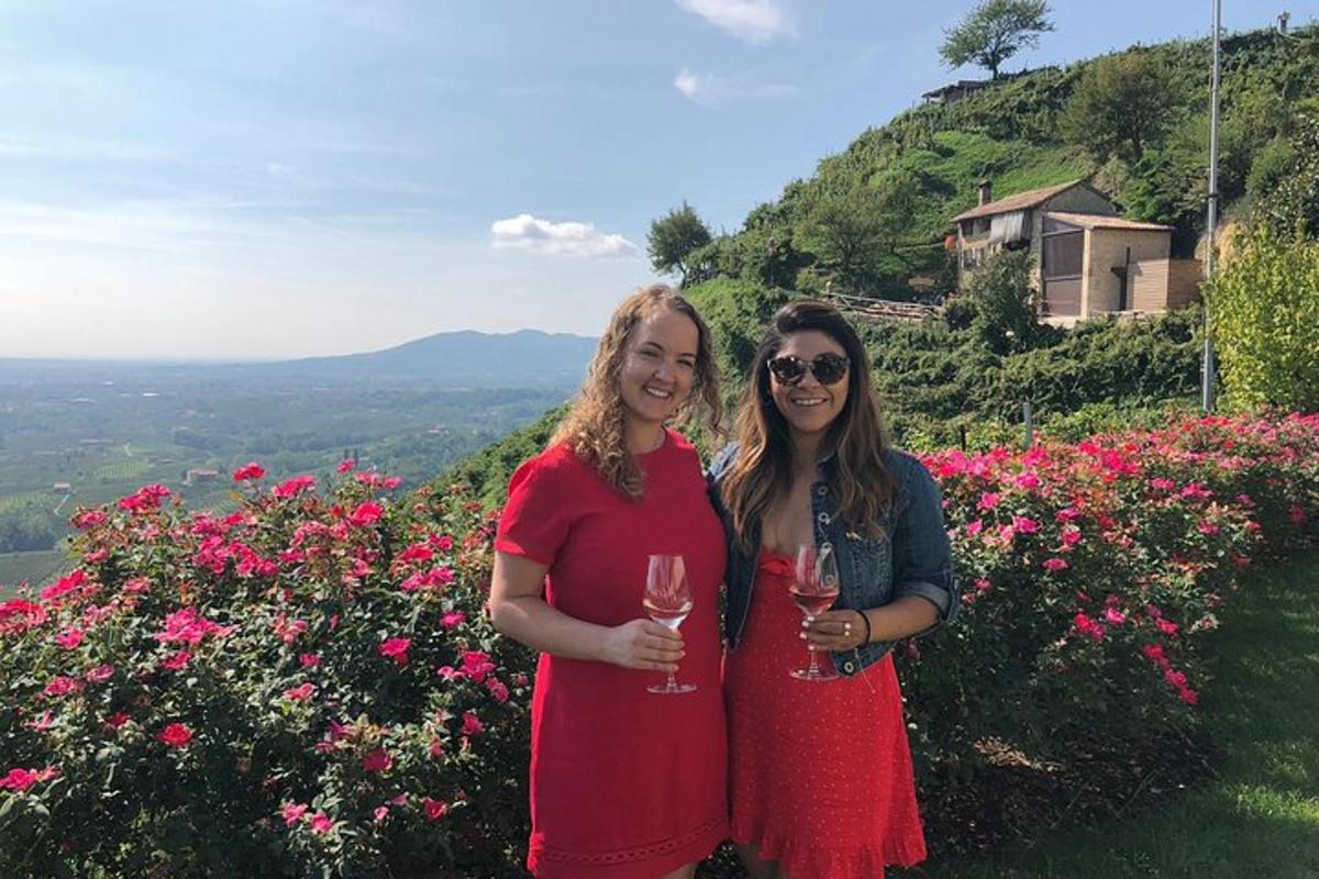 yan yana duran ve şarap kadehleri tutan iki kadın