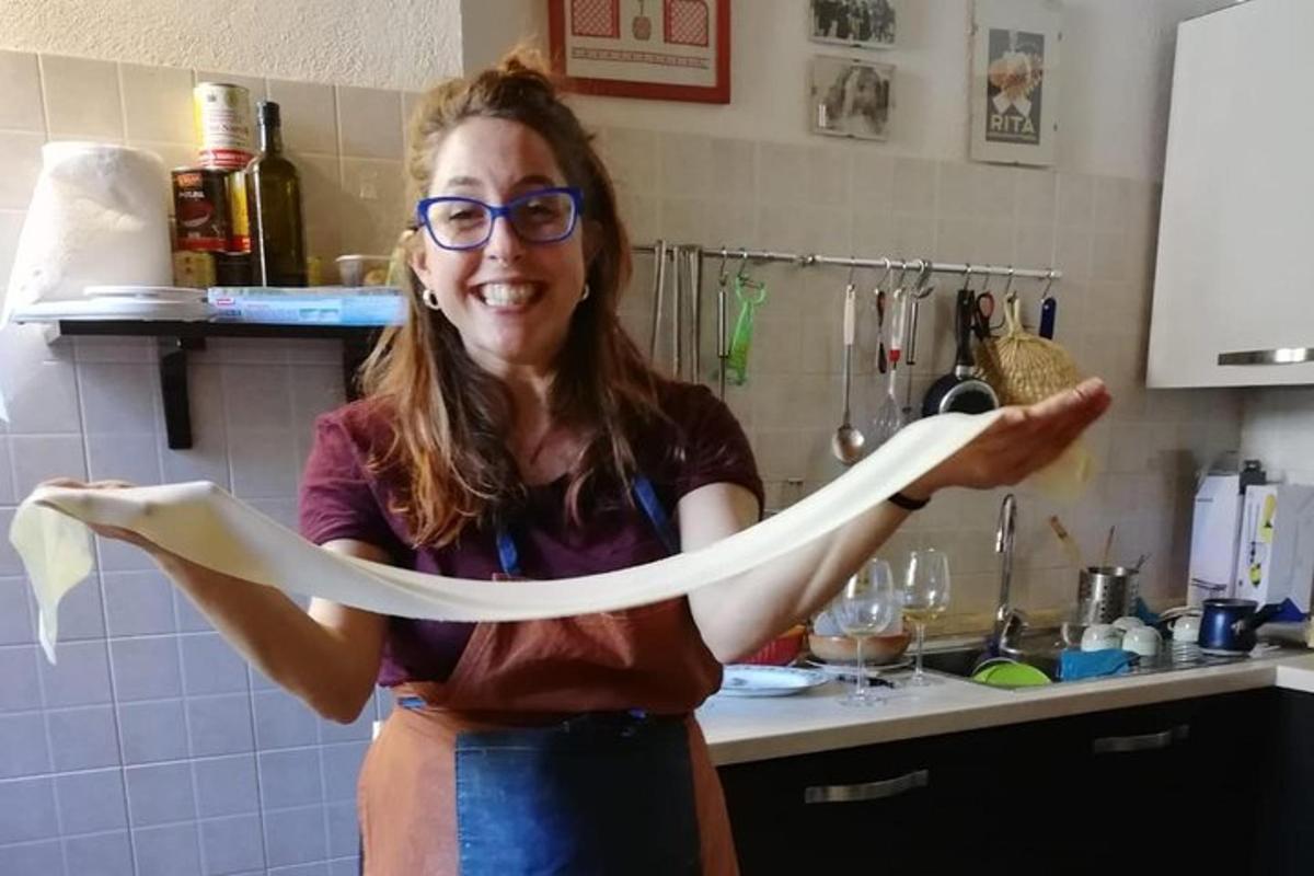 a woman holding a large piece of paper in a kitchen