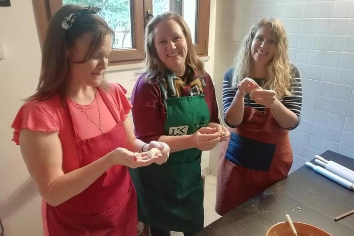 a group of three women standing in a kitchen eating food
