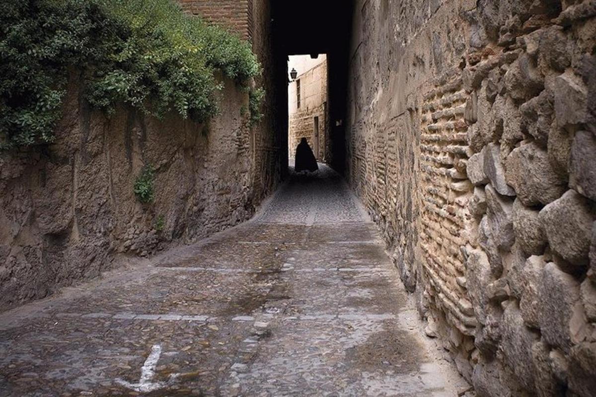 un vicolo con un tunnel in un muro di pietra