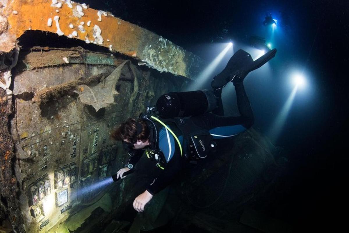 Una mujer con traje de buceo tumbada al lado de una pared