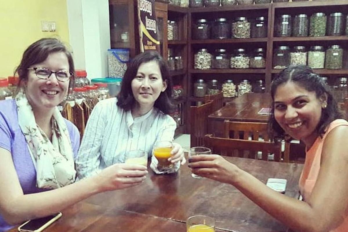 three women sitting at a bar with drinks