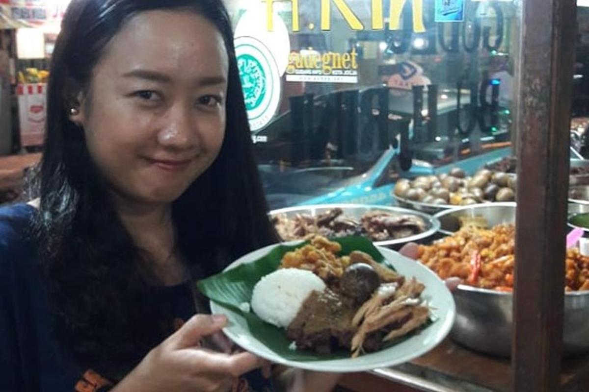 a woman is holding a plate of food
