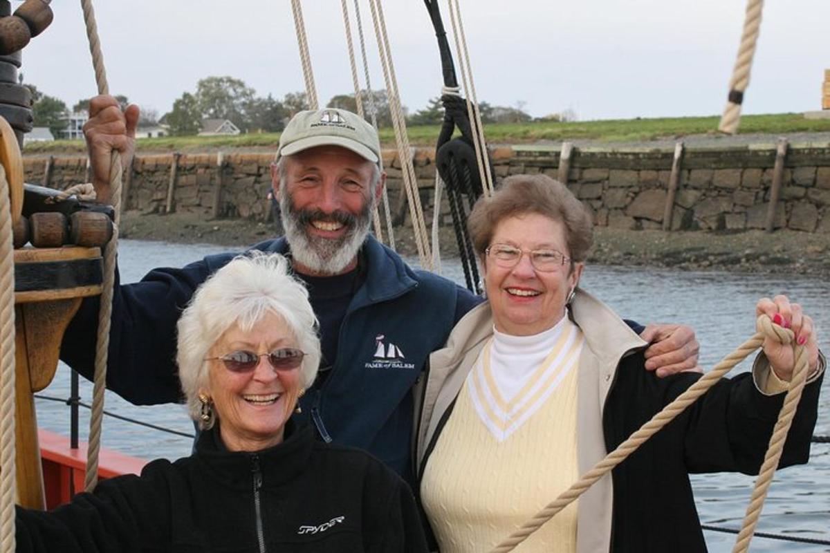duas mulheres e um homem em pé em um barco