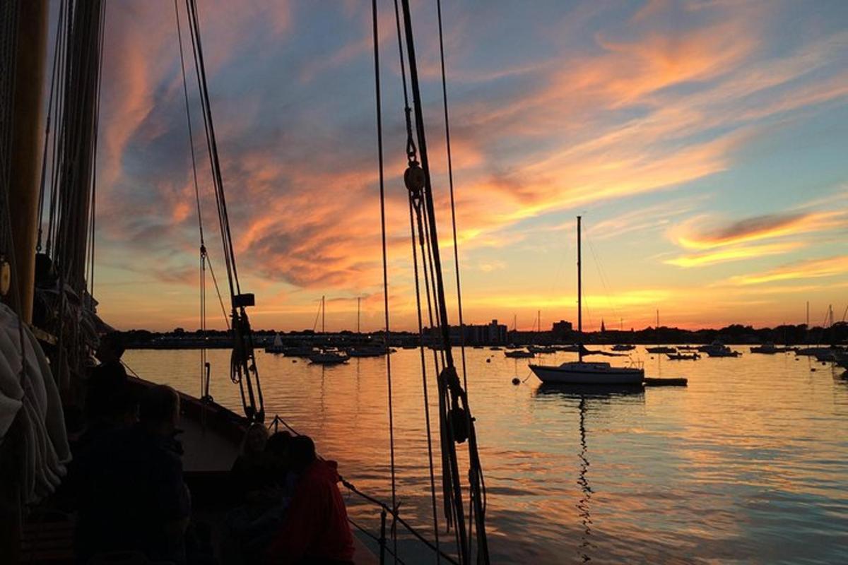 um grupo de barcos na água ao pôr do sol