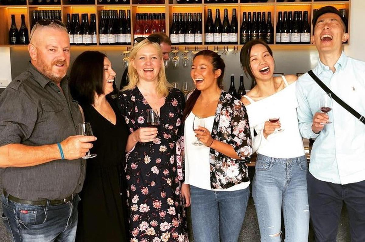 a group of people posing for a picture with wine glasses
