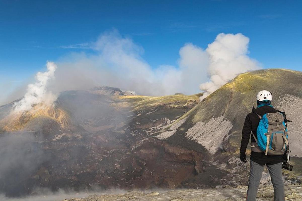 a man with a backpack standing on top of a mountain