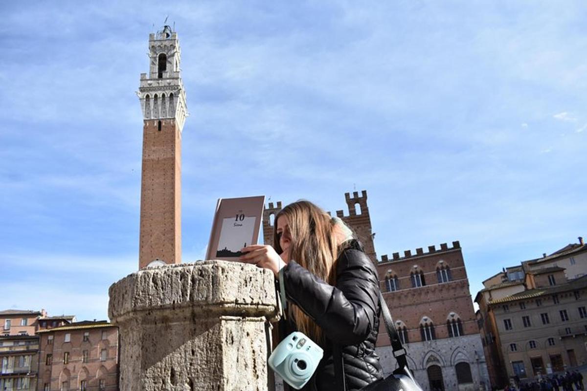 una donna che scatta una foto di una torre dell'orologio con un computer portatile