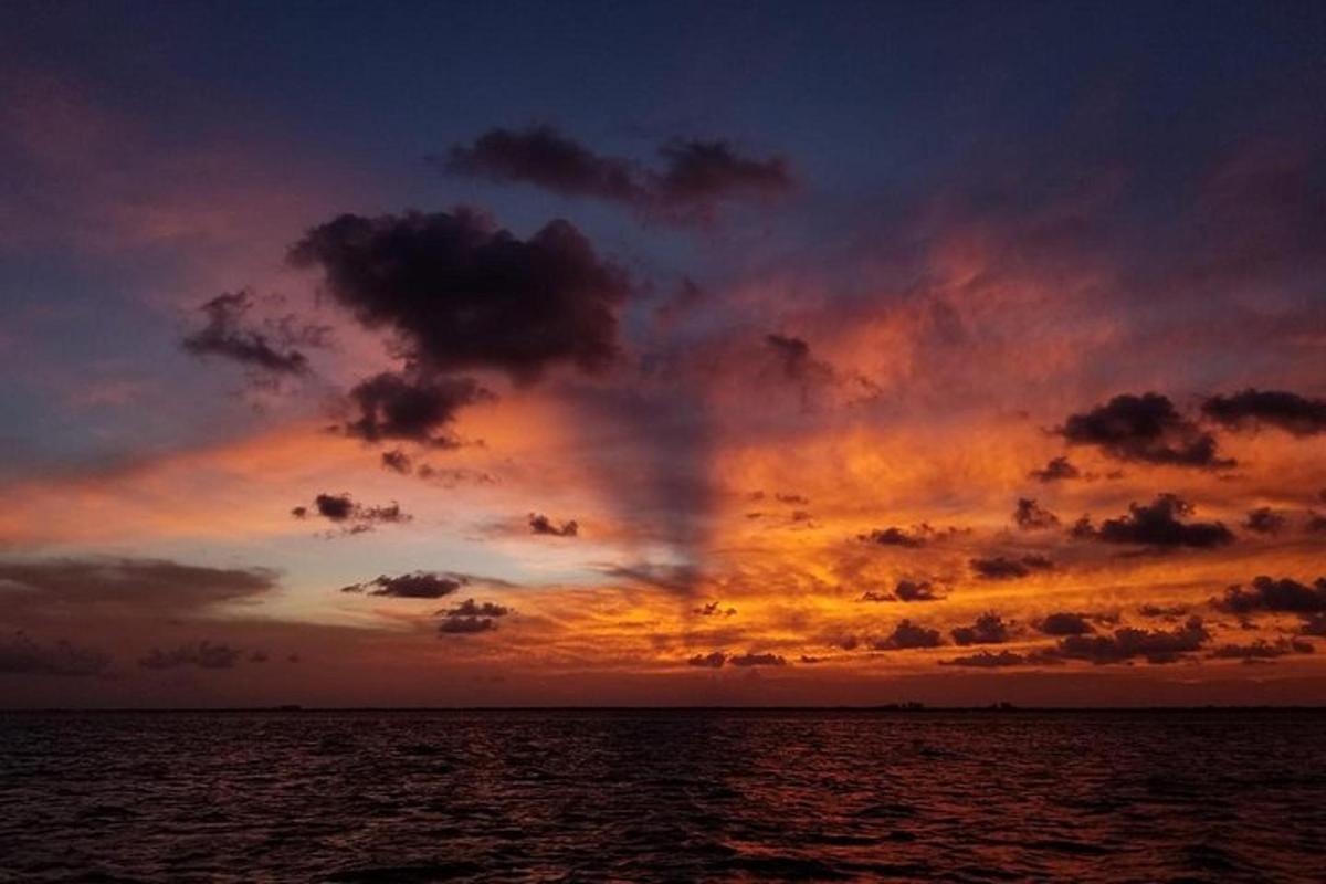 a sunset over the ocean with a cloudy sky