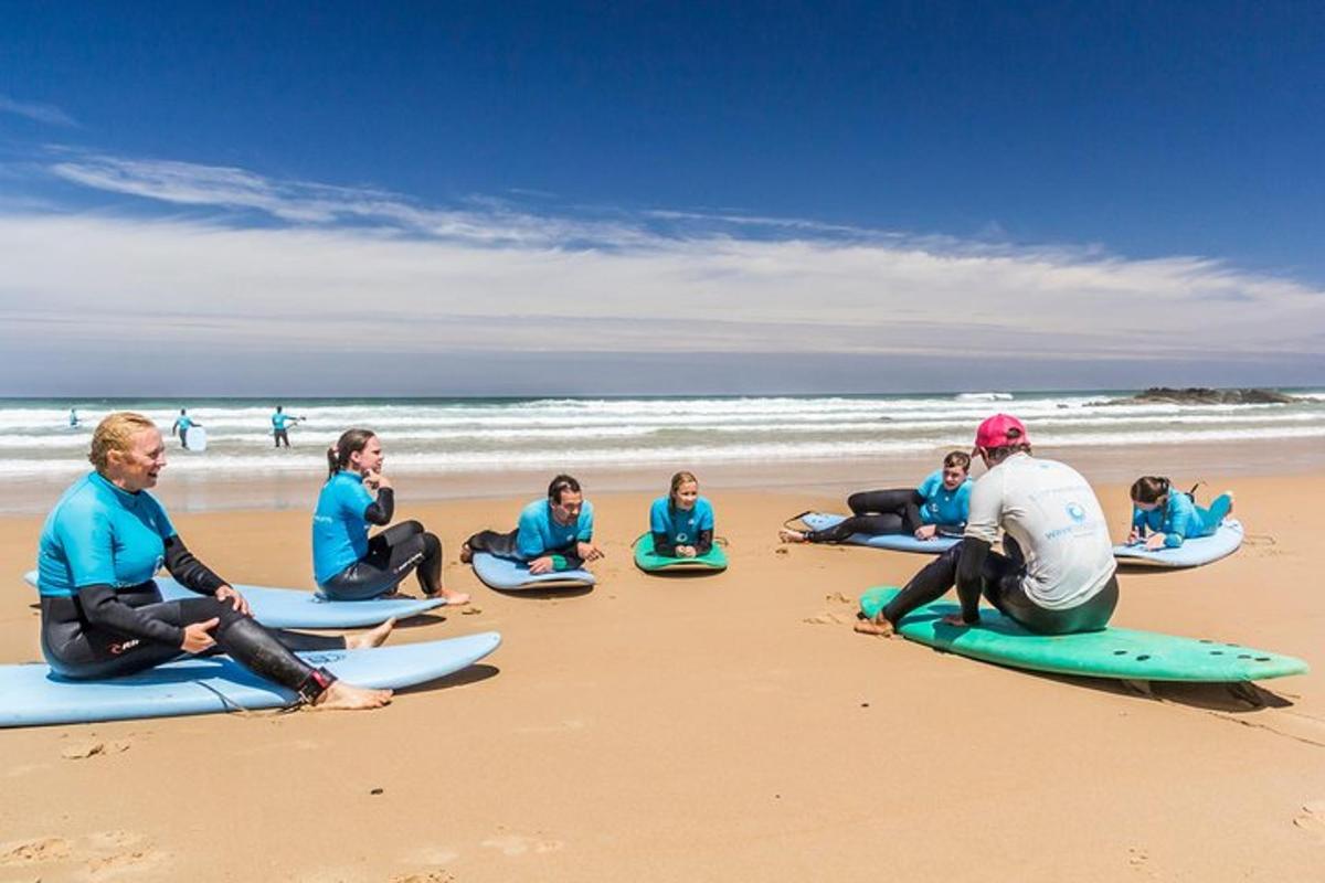 Grupa ludzi siedzących na deskach surfingowych na plaży