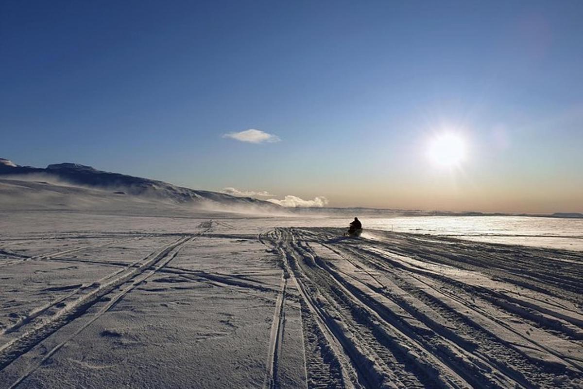 una persona asseguda a la platja a la neu