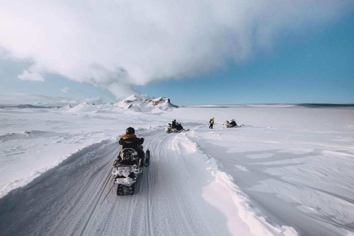 Un grupo de personas viajando en motos de nieve en la nieve.