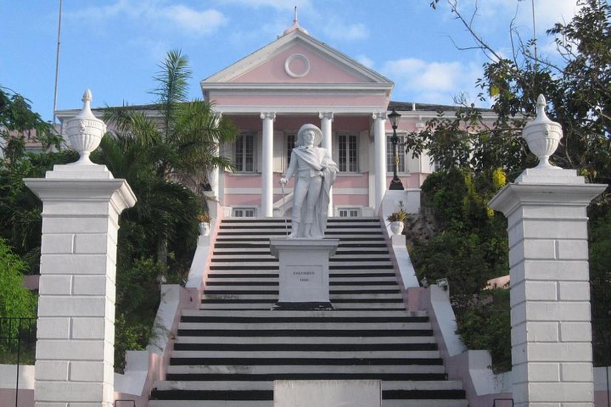 a statue of a woman in front of a pink building