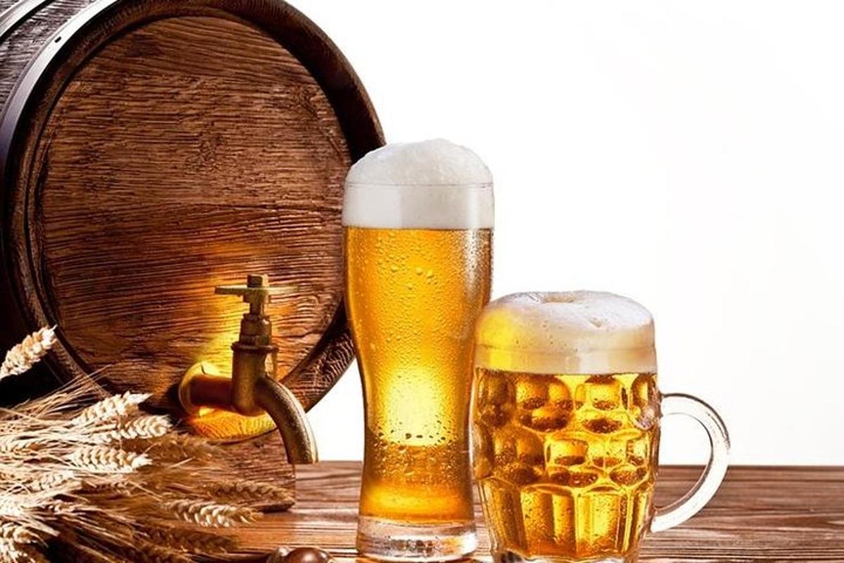 to glas øl står ved siden af en tønde