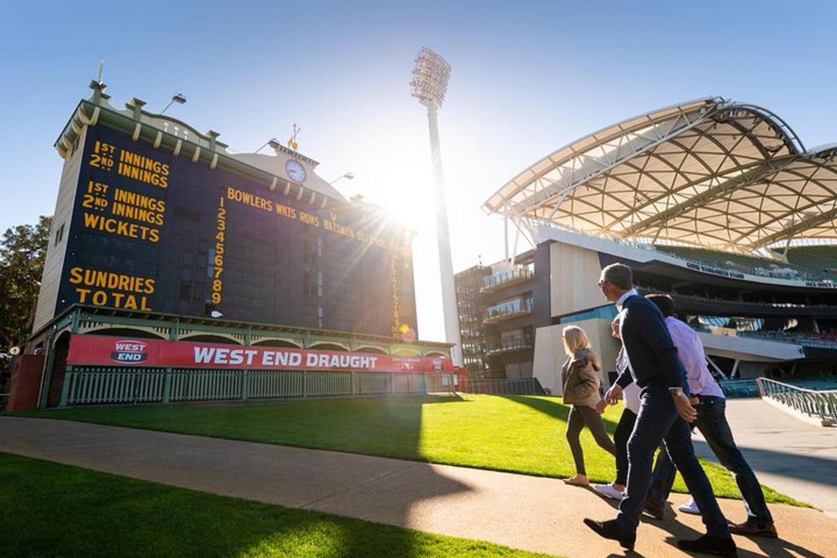two people walking in front of a baseball stadium