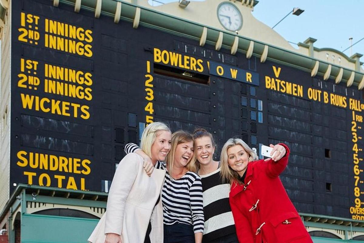 a group of people standing in front of a scoreboard