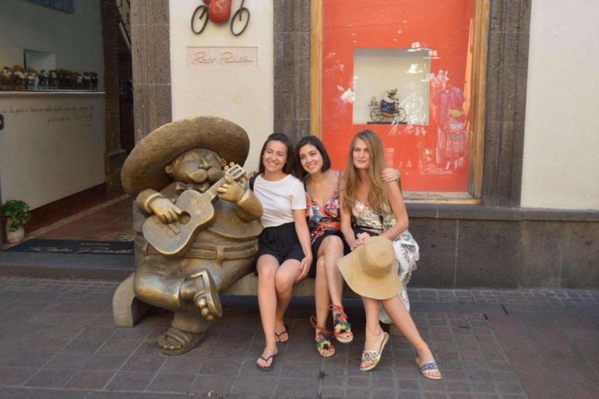 tre ragazze sedute su una statua di un orso