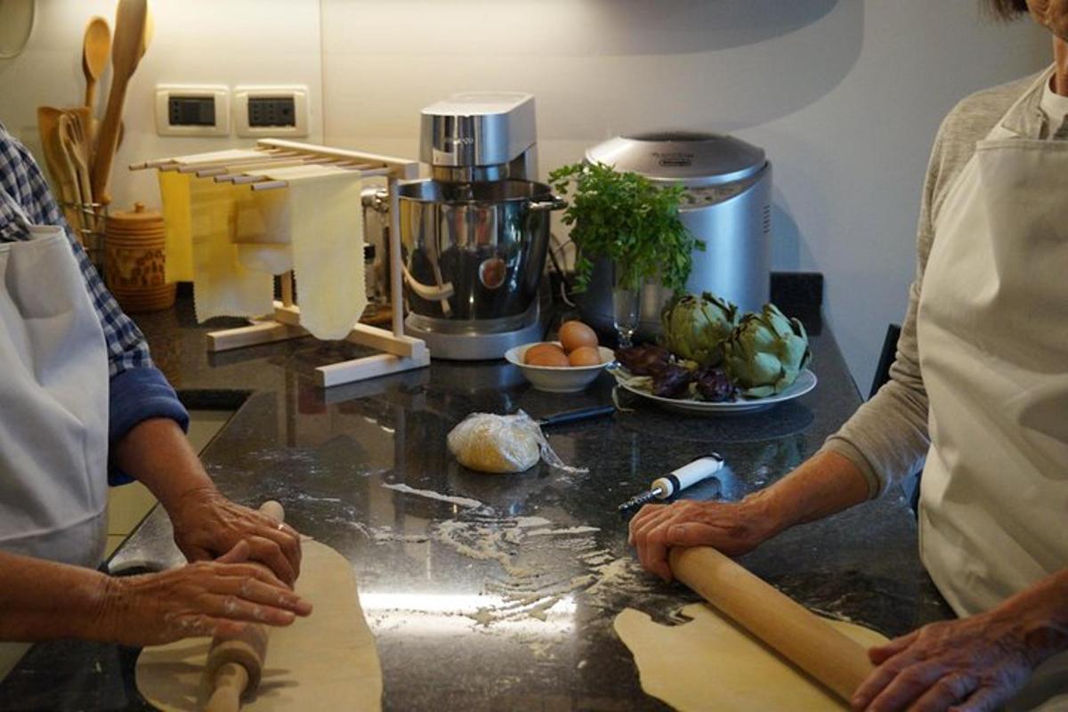 two people in a kitchen preparing food on a counter