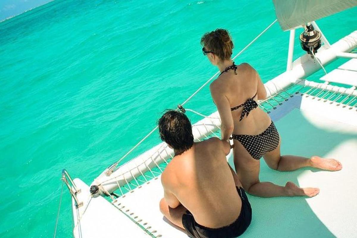 two people in bikinis sitting on the deck of a boat