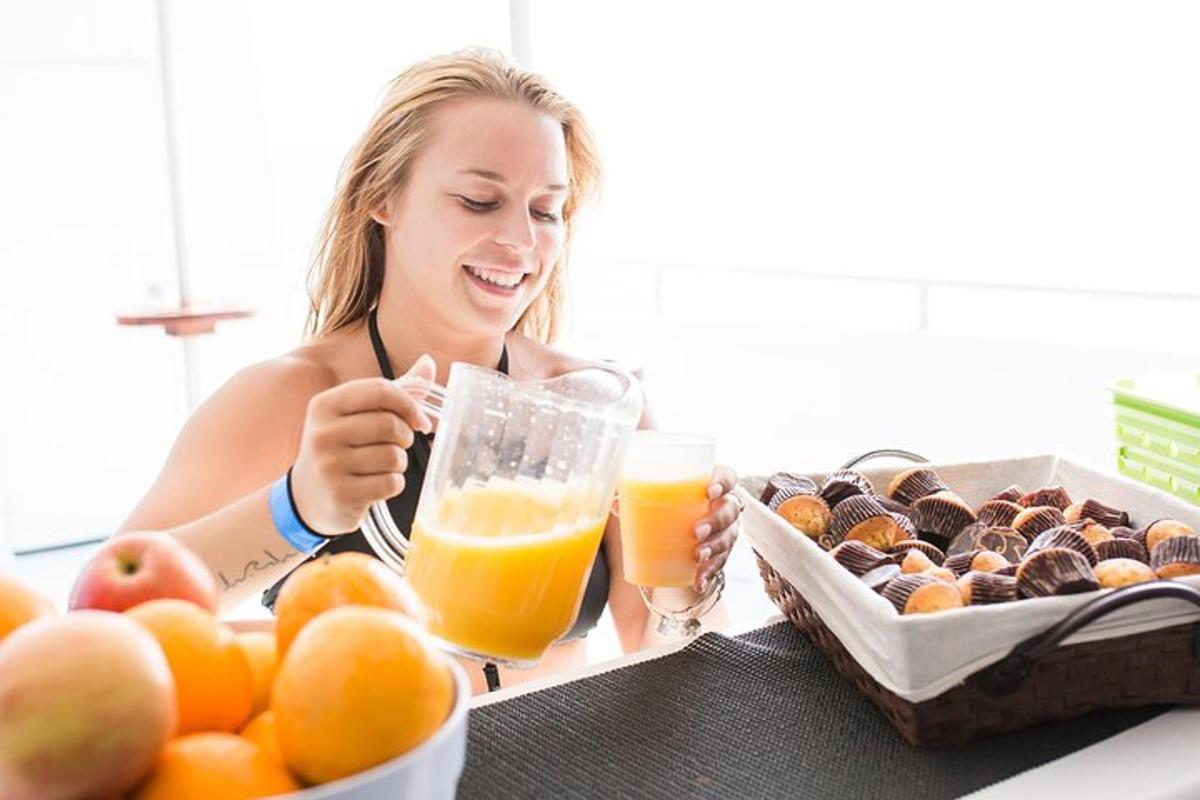 eine Frau sitzt mit einem Tablett Orangensaft an einem Tisch