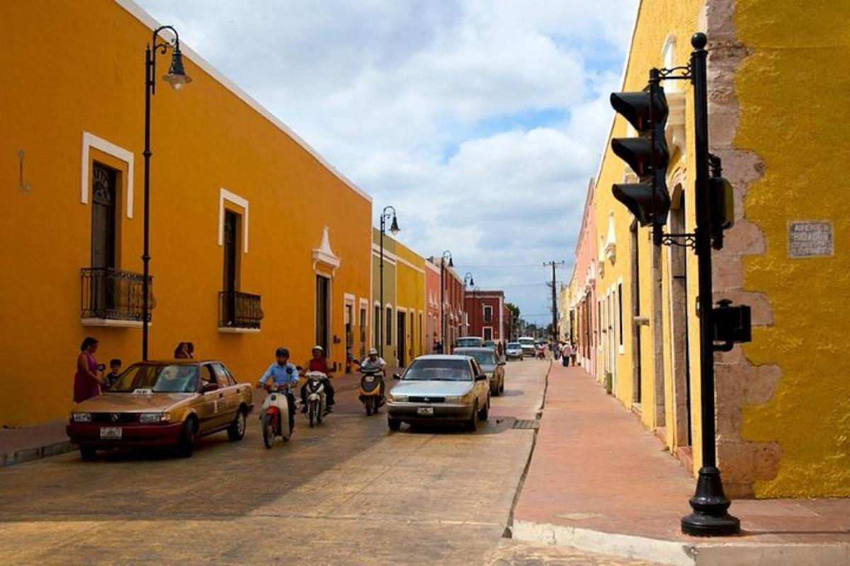 Una calle de la ciudad con coches y gente en bicicletas y coches.